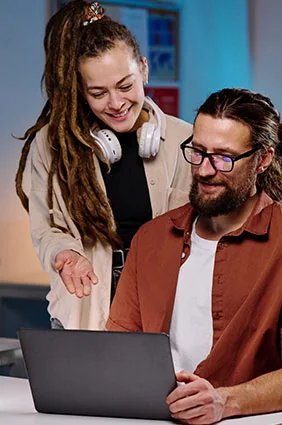 Two iNET SYSTEMS engineers reviewing work together on a laptop